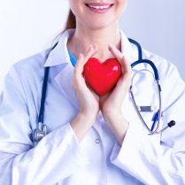 Young,Woman,Doctor,Holding,A,Red,Heart,,Isolated,On,White Young woman doctor holding a red heart, isolated on white background